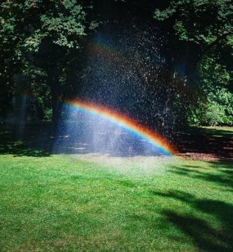 Arc de Sant Martí a casa amb els aspersors de reg del jardí